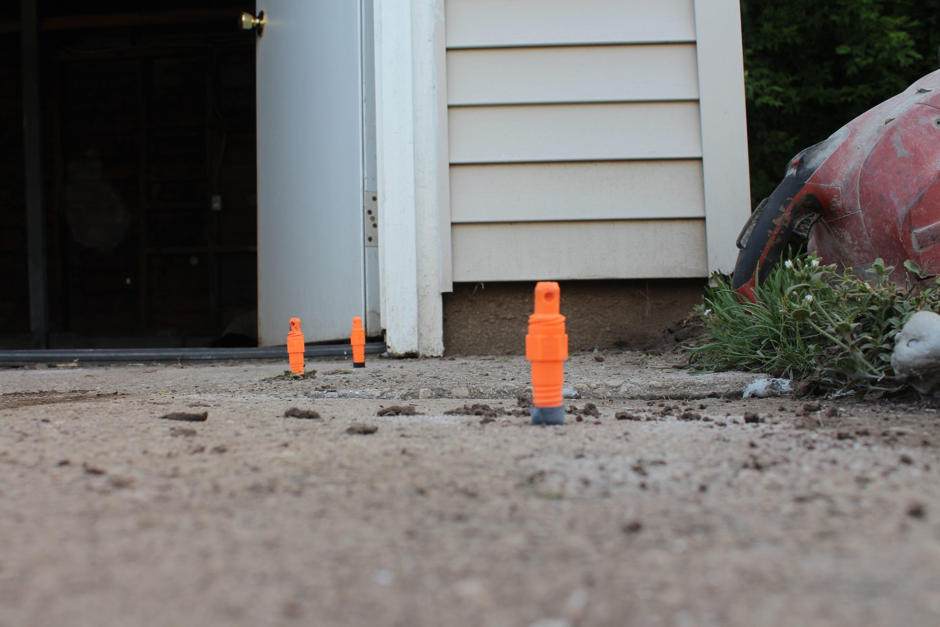 Foam injection ports drilled in concrete slab during polyurethane lifting process